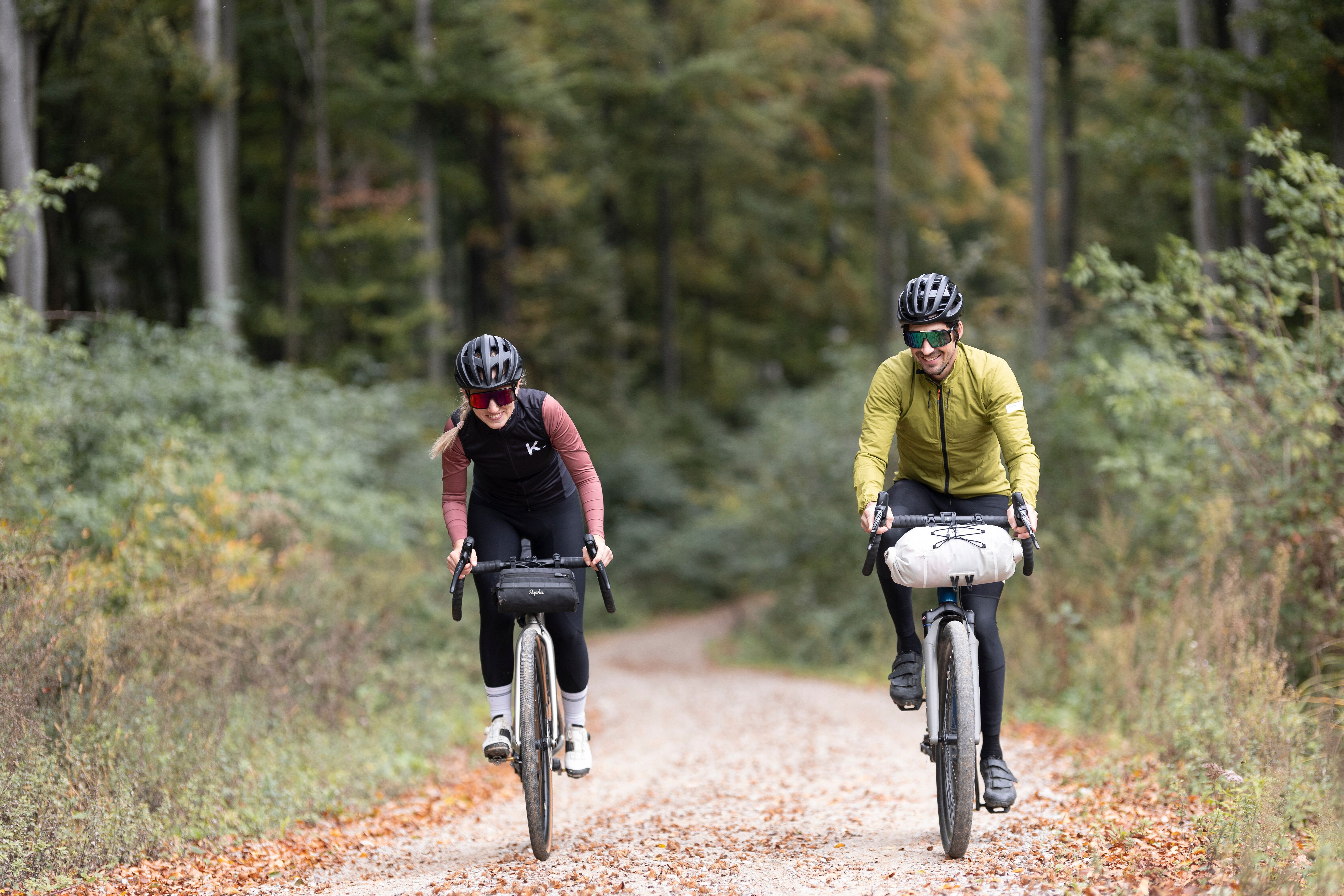 Zwei Radfahrer genießen die frische Luft und die malerische Landschaft des Wienerwaldes. Umgeben von hohen Bäumen und bunten Blättern, strahlt die Natur in voller Pracht und lädt zu einem unvergesslichen Abenteuer ein.