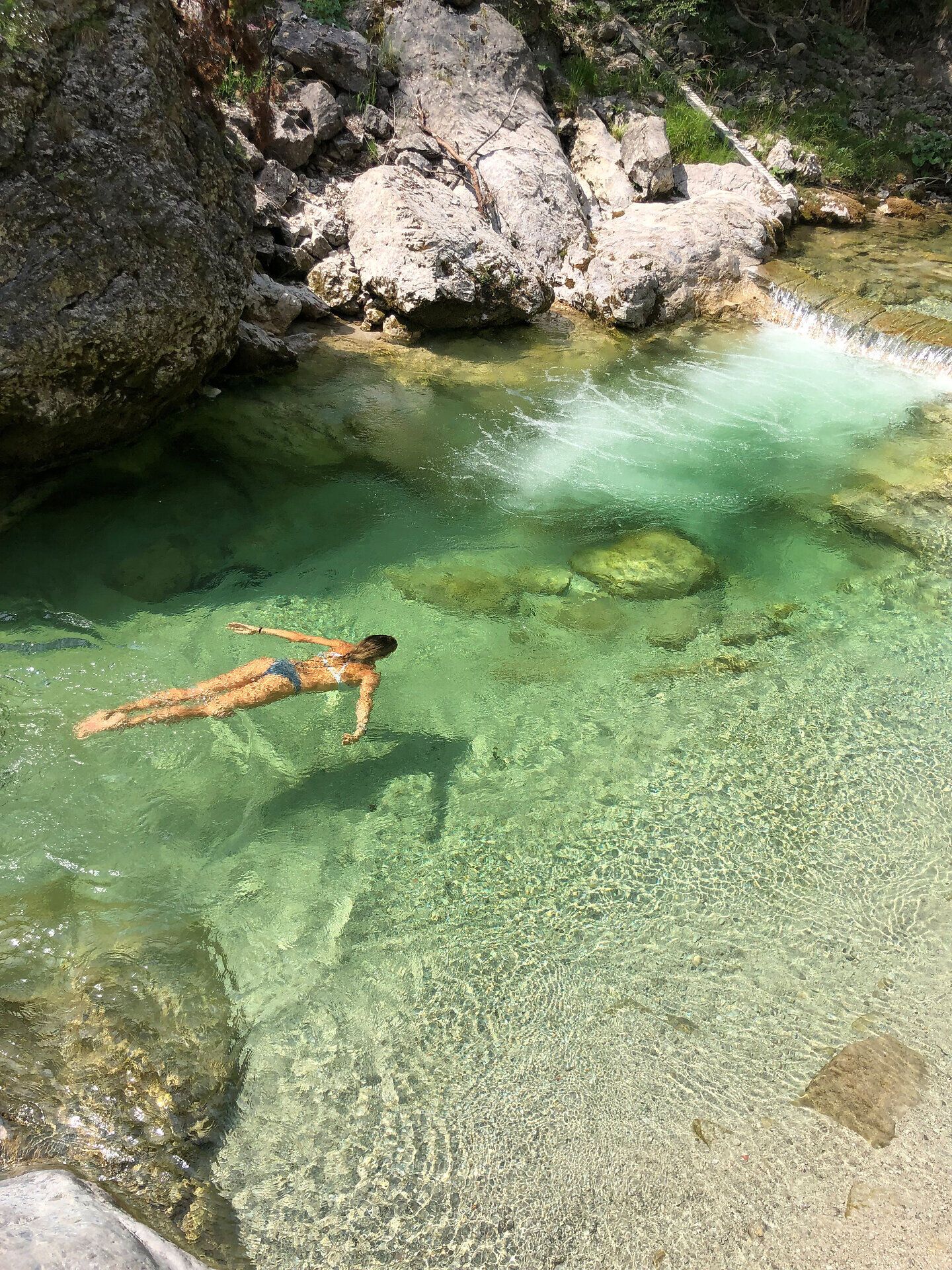 Kristallklares Wasser umschmeichelt den Körper, während die sanften Wellen eine beruhigende Melodie erzeugen. Umgeben von majestätischen Felsen und üppigem Grün, lädt dieser Ort zum Entspannen und Träumen ein. Hier, wo die Natur in ihrer reinsten Form erstrahlt, wird jeder Moment zu einem unvergesslichen Erlebnis.