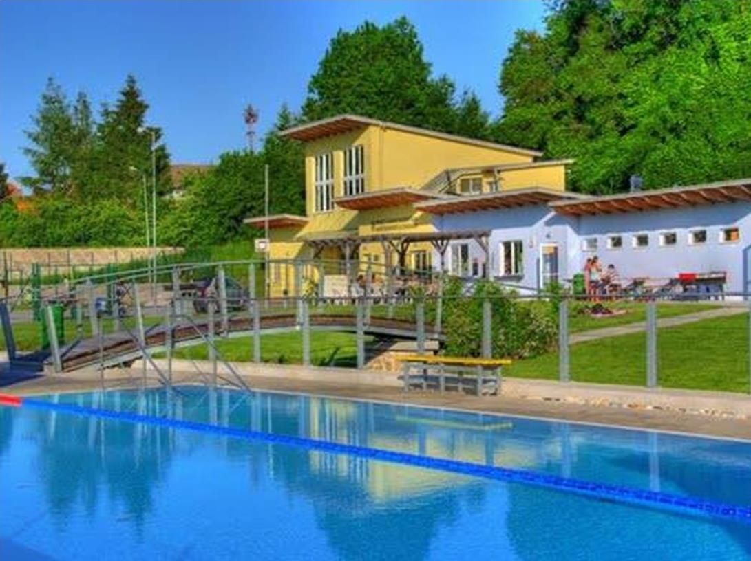 Freibad Altlengbach mit Schwimmbecken und Gebäude im Hintergrund.