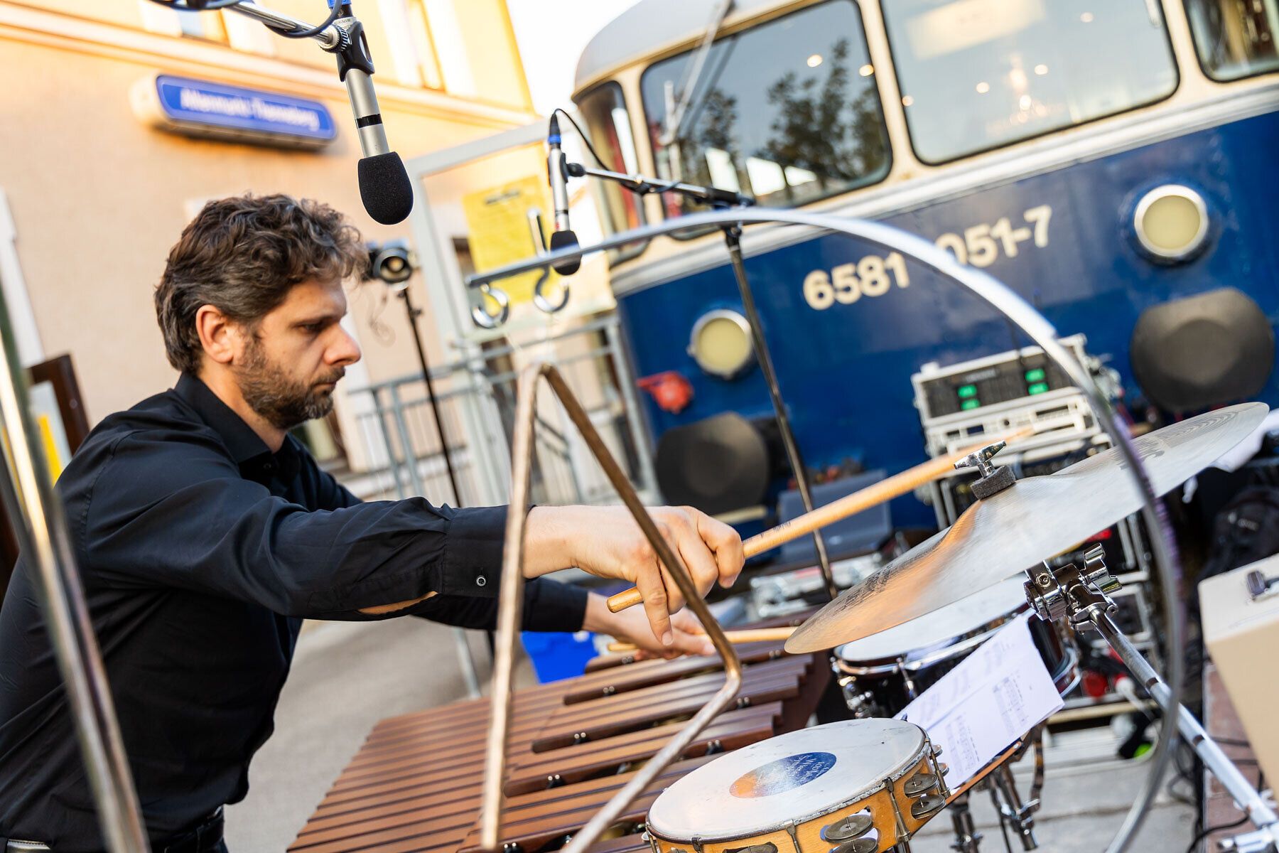 Ein talentierter Musiker bringt mit seinen rhythmischen Klängen Leben in die sommerliche Atmosphäre des Kulturbahnhofs. Umgeben von der charmanten Kulisse des Triestingtals, genießen die Besucher die harmonische Verbindung von Musik und Natur.