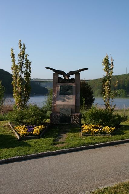 Denkmal von Wilhelm Kress in Tullnerbach vor einem See.