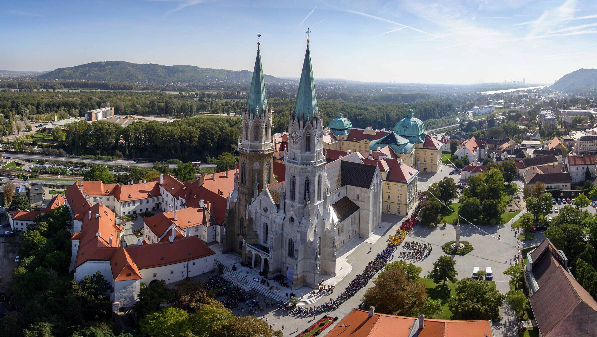 Die majestätischen Türme des Stifts erheben sich stolz über die malerische Landschaft, umgeben von sanften Hügeln und üppigem Grün. Ein Ort der Ruhe und Besinnung, der Besucher mit seiner beeindruckenden Architektur und der idyllischen Umgebung verzaubert.