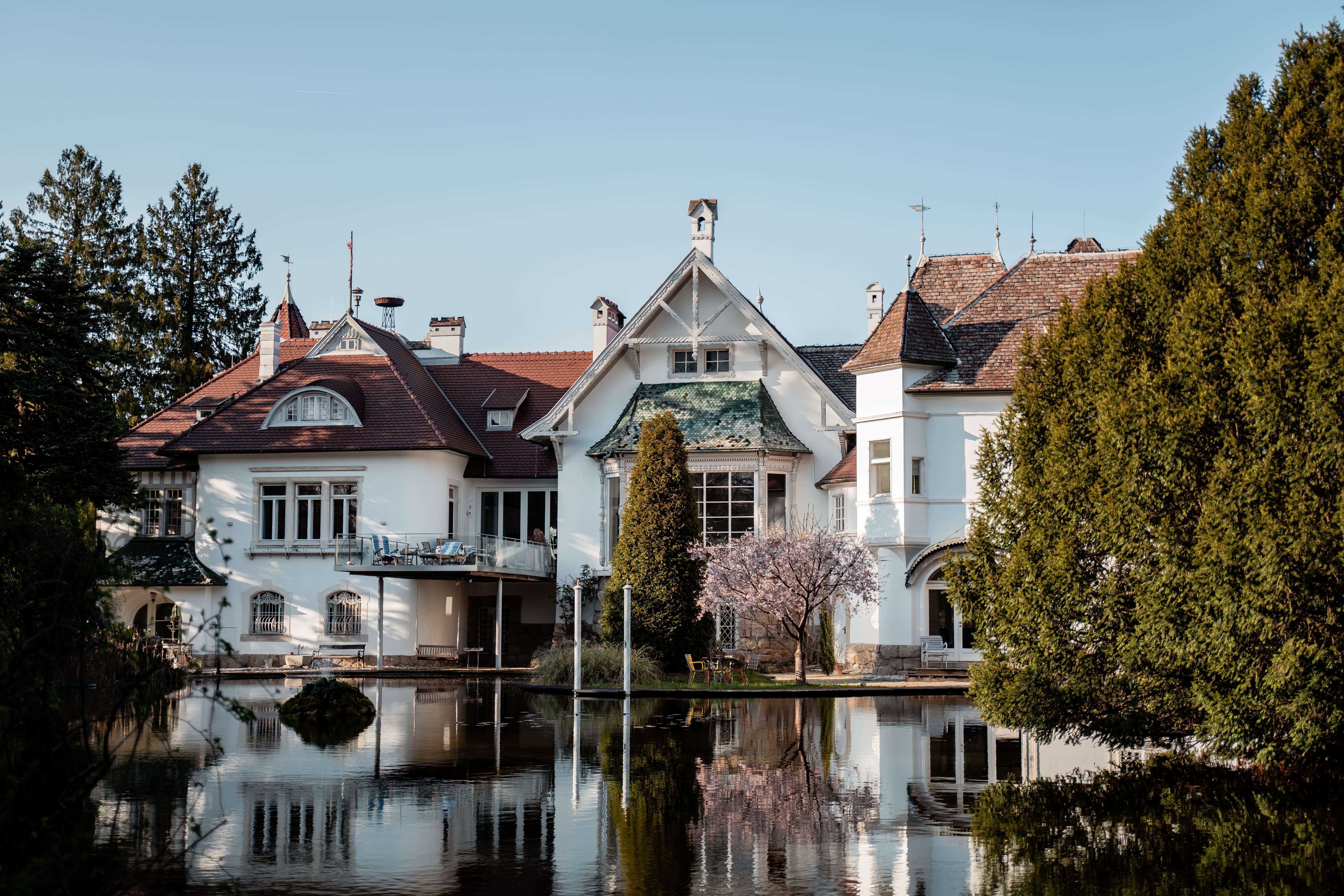 Das Schloss Schönau umgeben von einer wunderbaren Kulisse mit einem Teich. 