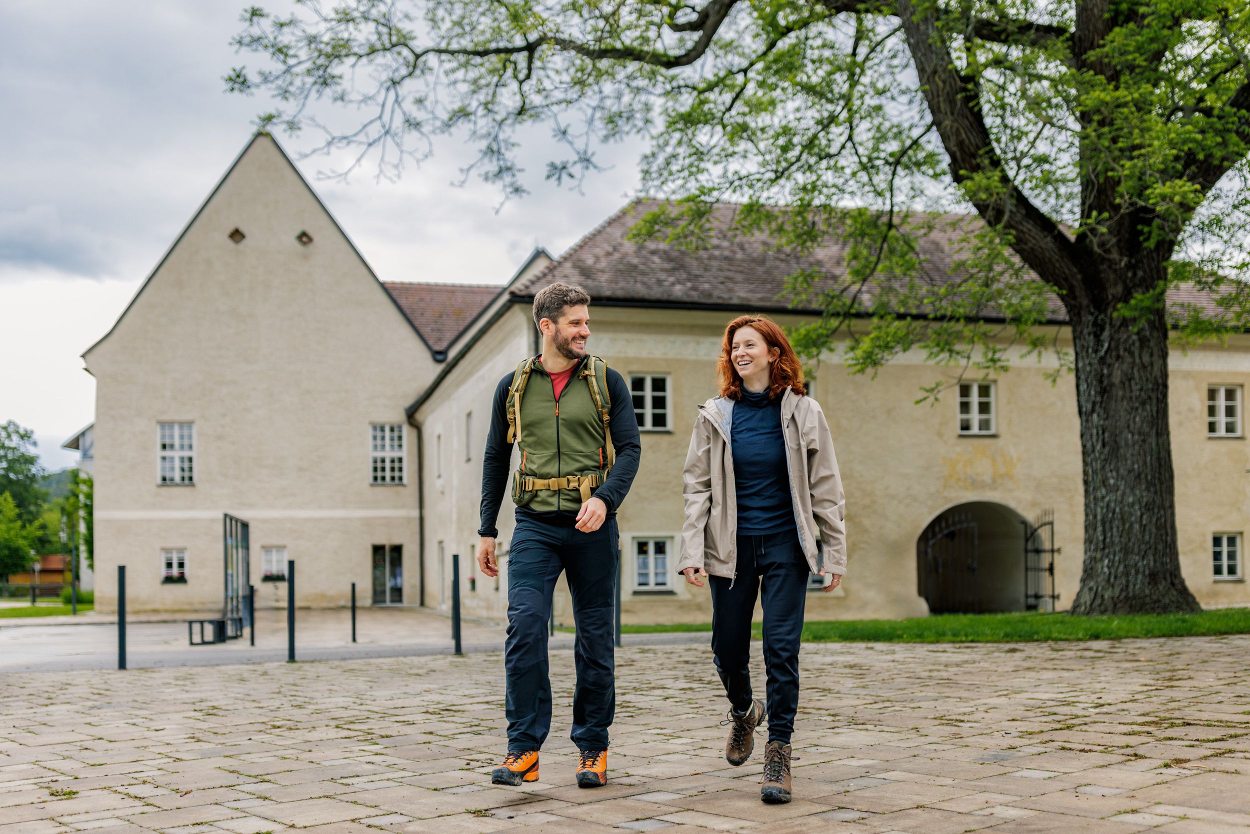 Zwei Wandernde vor dem historischen Schloss Katzelsdorf
