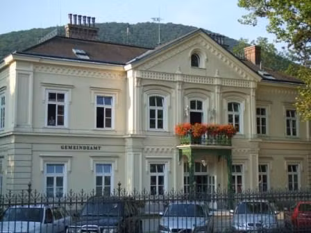 Historisches Gebäude mit Balkon und Blumen in Hinterbrühl.