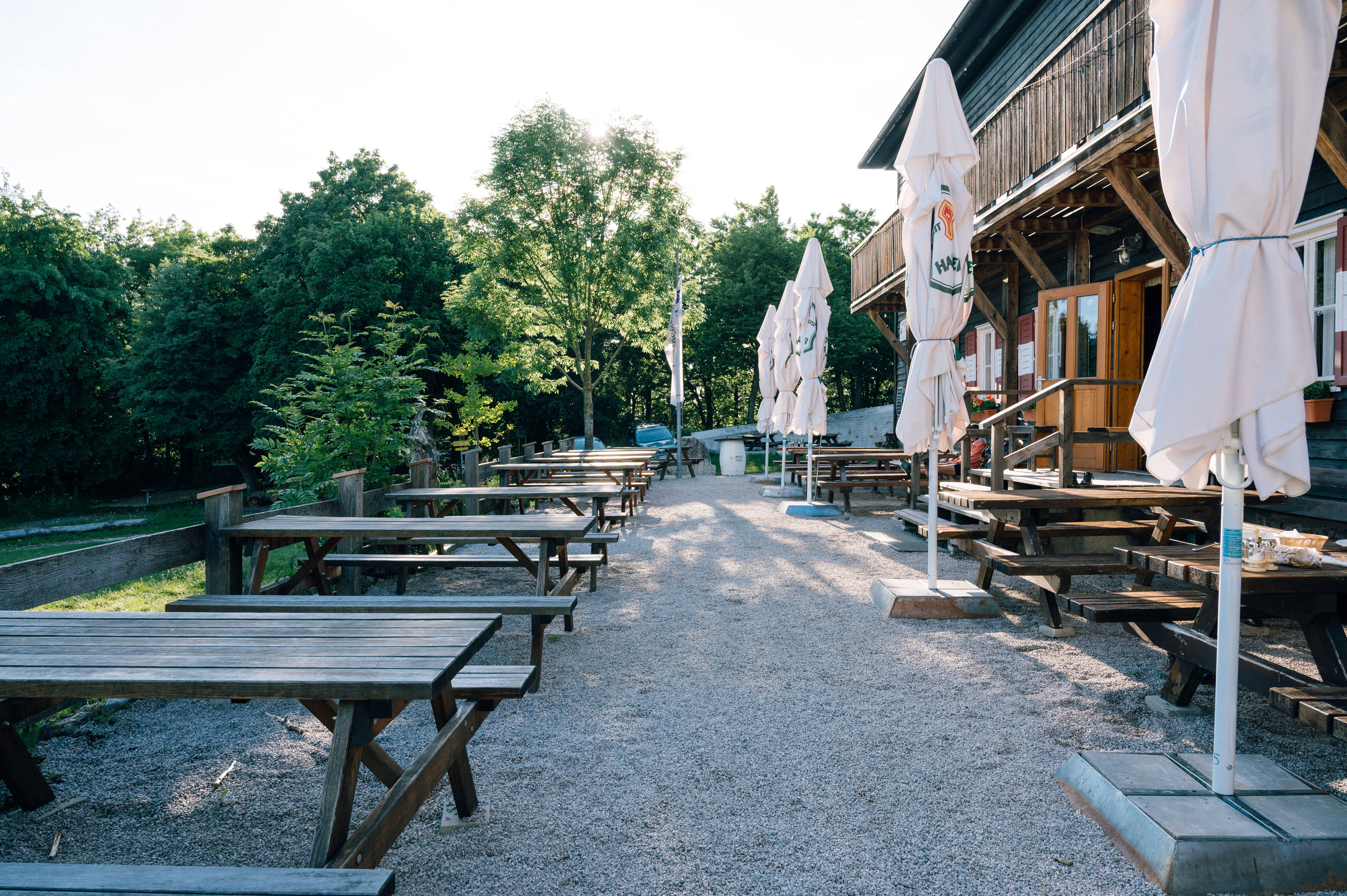 Gastgarten vom Peilsteinhaus mit Tischen, Bänken und Schirmen