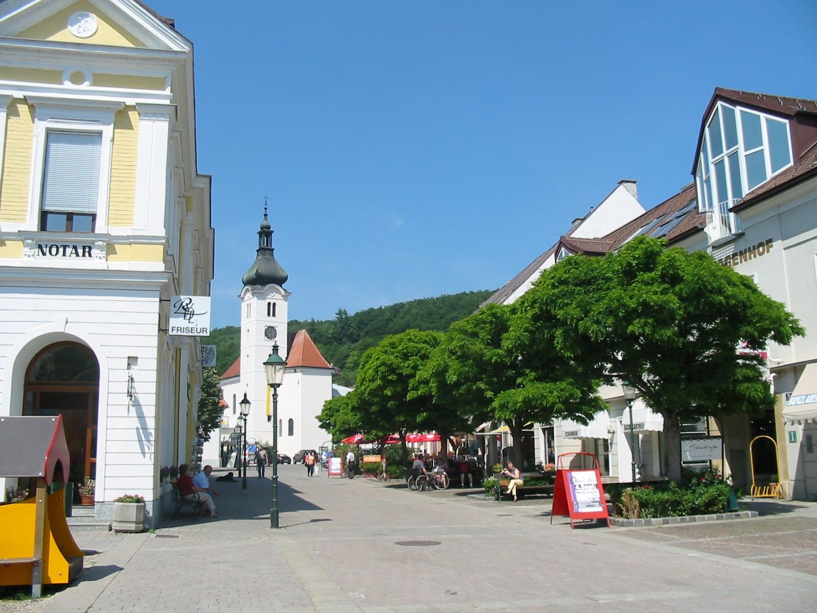 Hauptplatz in Purkersdorf mit Kirche und Geschäften.