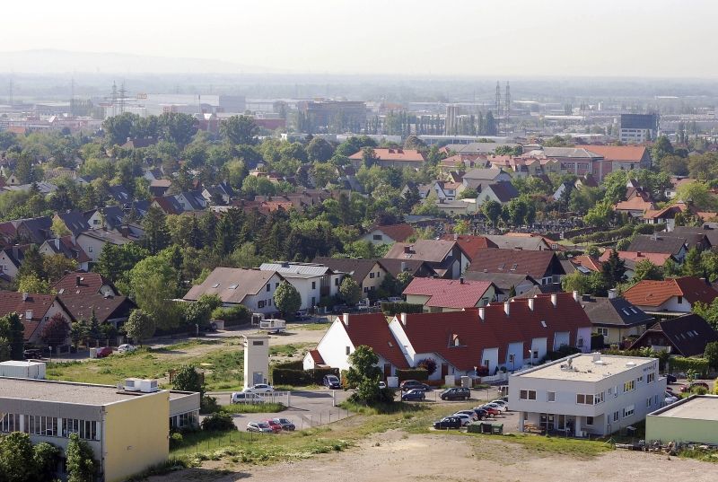 Luftaufnahme von Wiener Neudorf mit Wohnhäusern und Industriegebäuden im Hintergrund.
