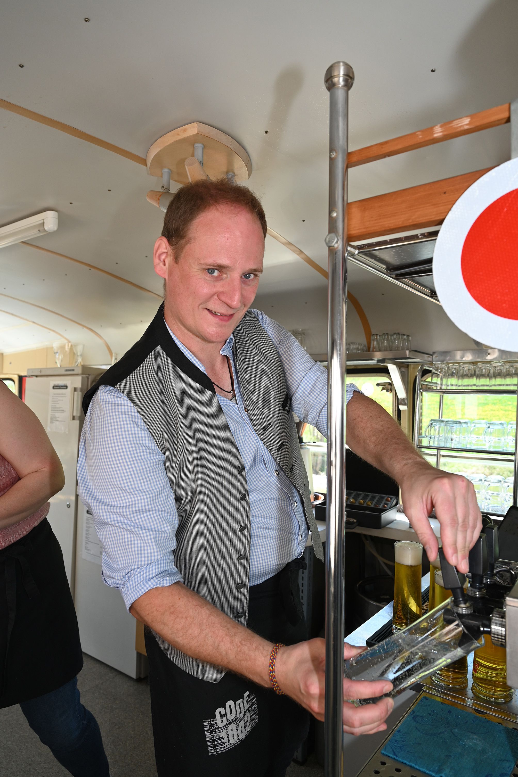 Matthias Schorn steht im Getränke-Waggon vom Kulturbahnhof und zapft Bier