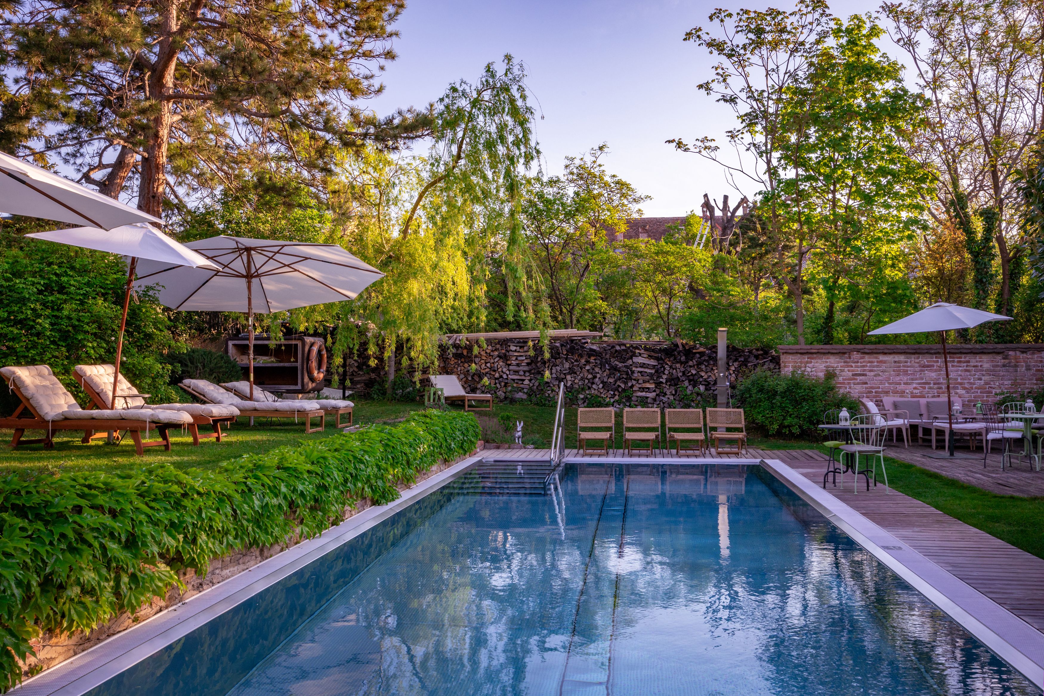 Garten mit Pool, Liegestühlen und Sonnenschirmen im Hotel Landhaus Moserhof.
