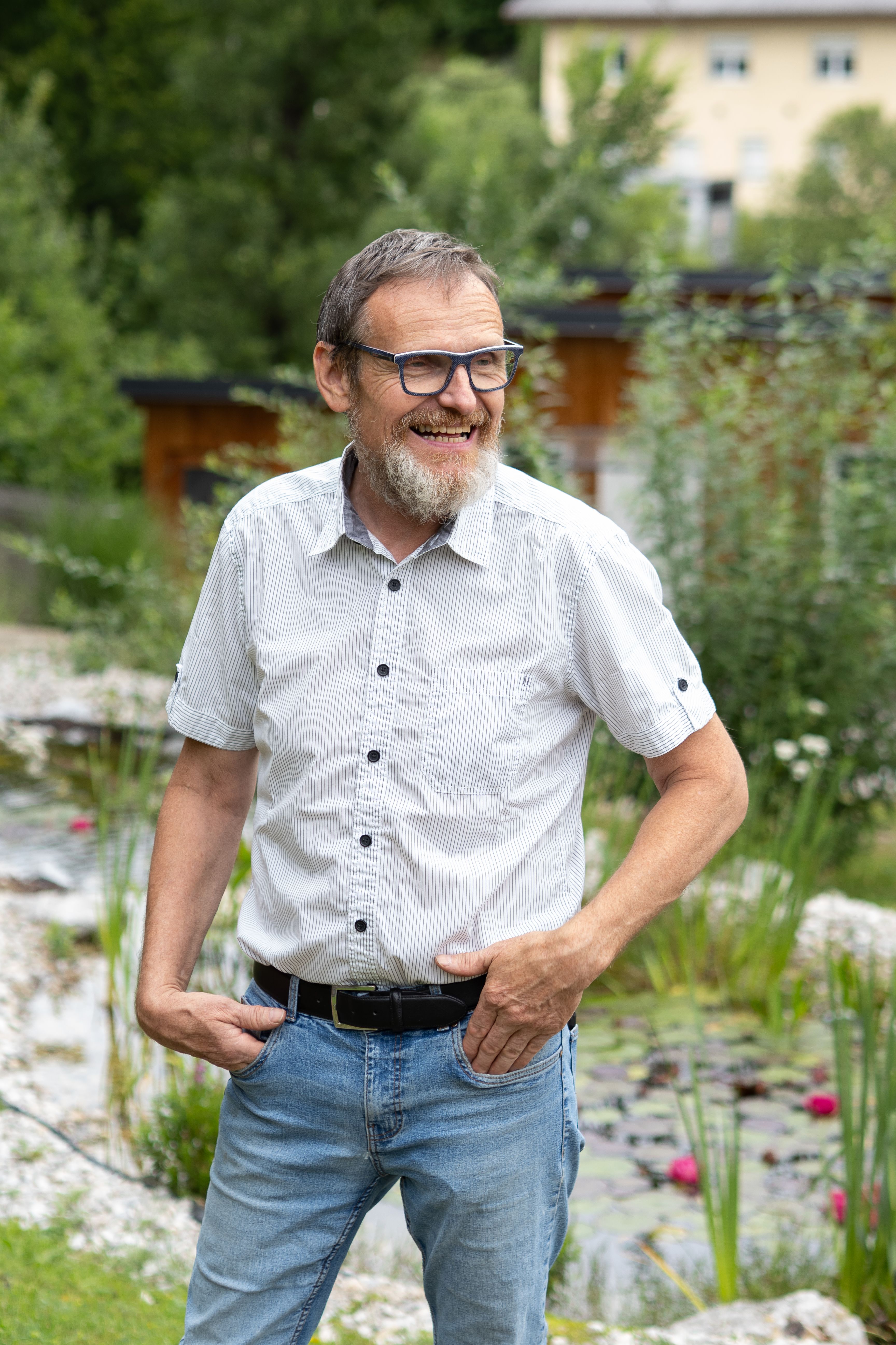 Hausherr Alfred Brandtner in seinem Garten vor einer Steinmauer