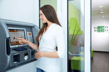 Frau bedient einen Check-in-Automaten in einem modernen Empfangsbereich.