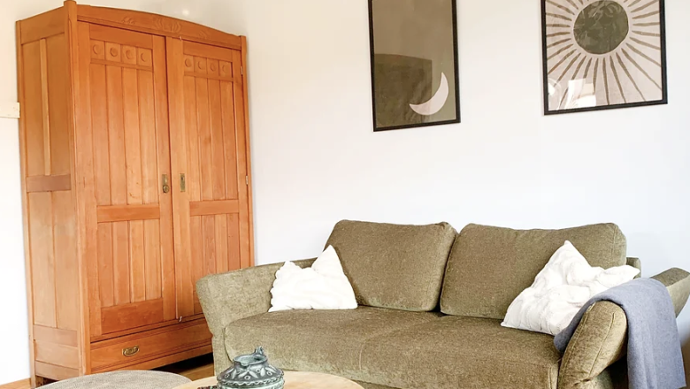 TDR-Chalet Wienerwald-stylish living room, © Obermeier green sofa in room with wooden floor and wardrobe