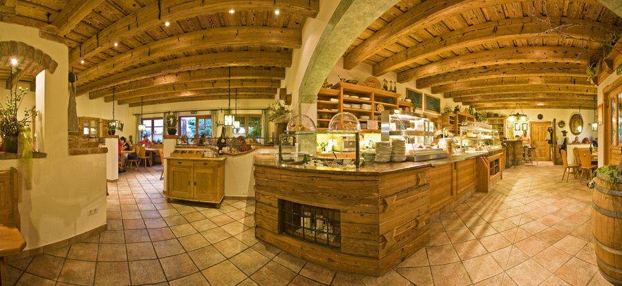 Innenansicht eines gemütlichen Heurigenlokals mit Holzbalkendecke und rustikaler Einrichtung.