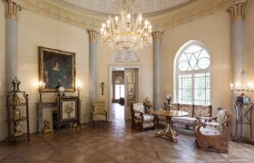 Eleganter Raum im Geym&uuml;llerschl&ouml;ssel mit Kronleuchter, antiken M&ouml;beln und Gem&auml;lde.