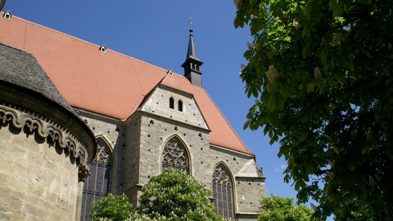 Kirche St. Othmar mit rotem Dach und grünem Baum im Vordergrund.