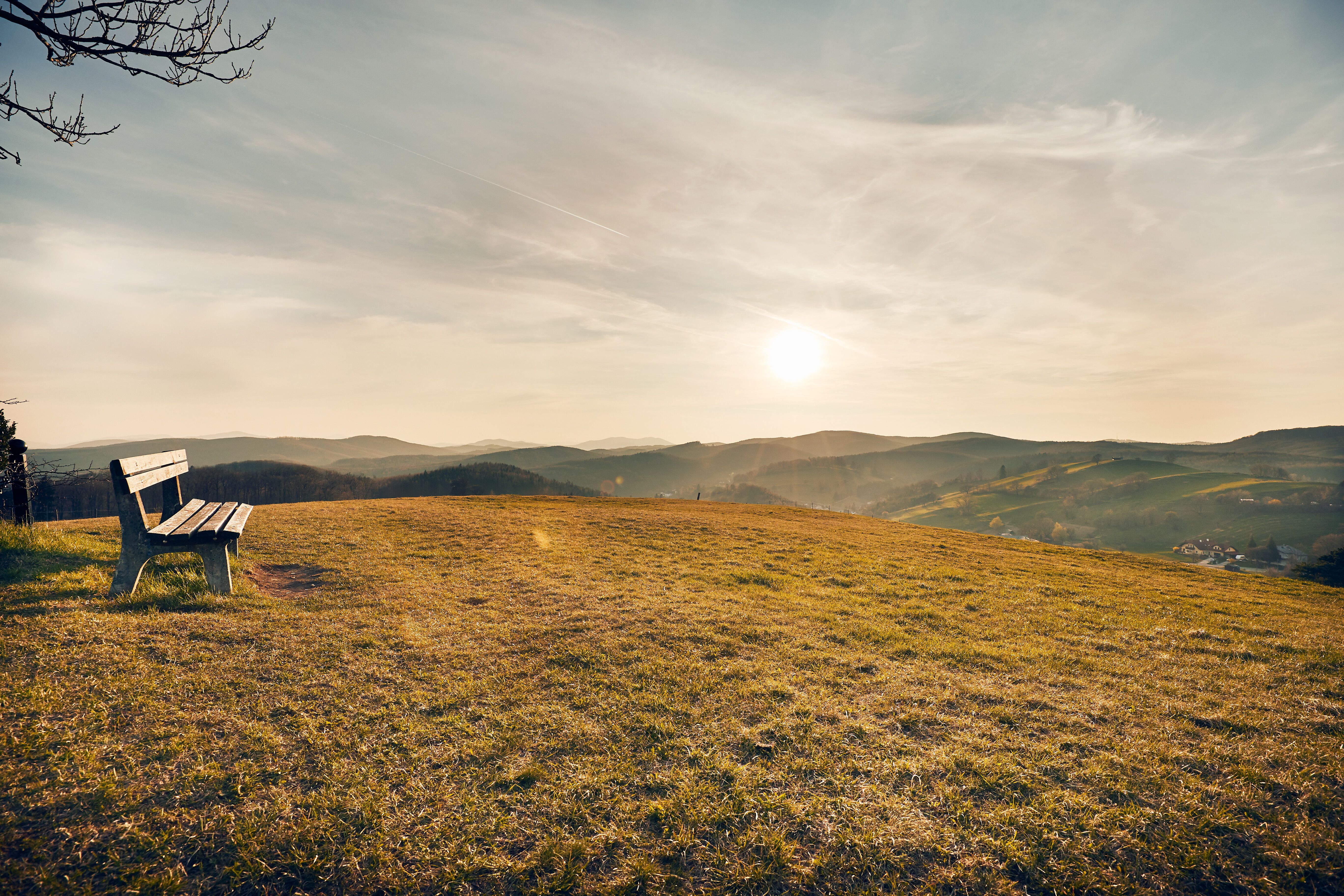 Die sanften Hügel des Wienerwaldes laden zu einem entspannten Aufenthalt ein. Eine einsame Bank auf der Wiese bietet den perfekten Platz, um den Sonnenuntergang über der malerischen Landschaft zu genießen. Hier verschmelzen Natur und Ruhe zu einem unvergesslichen Erlebnis.