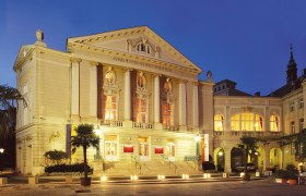 The Stadttheater Baden at night, illuminated with warm light.