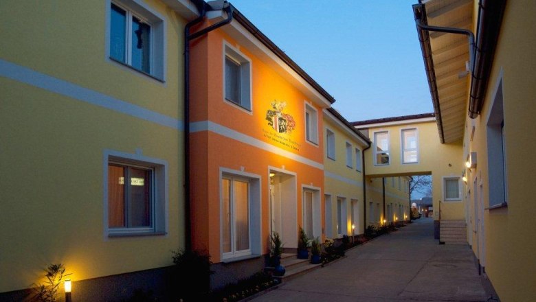 Außenansicht des Hotel Radlinger bei Dämmerung mit gelben und orangefarbenen Fassaden.