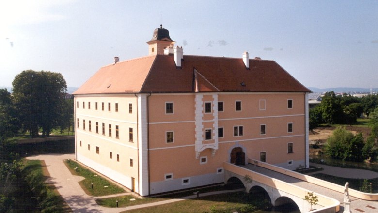Schloss Vösendorf mit Brücke und Gartenanlage.
