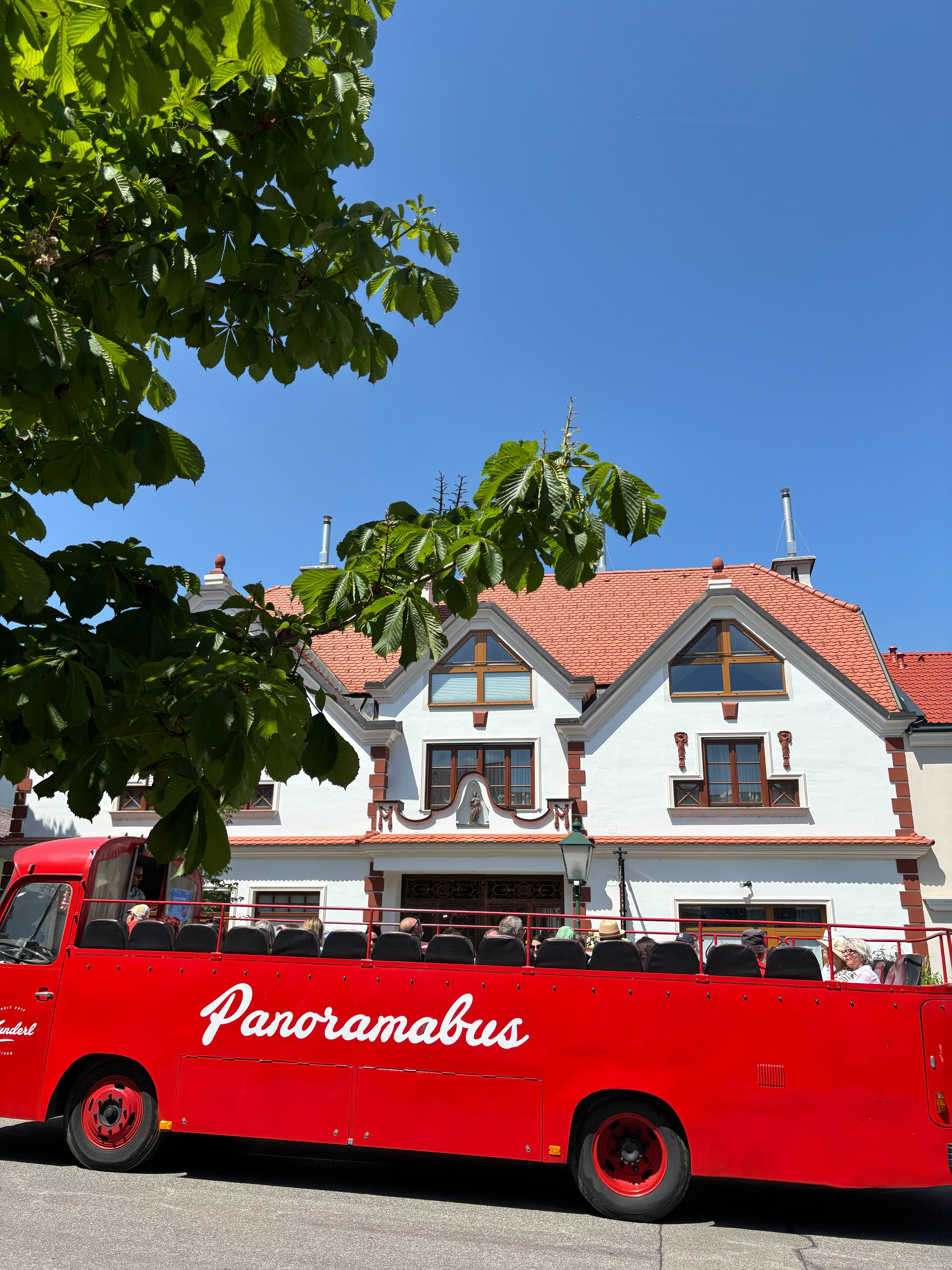 Oldtimer Bus parkt an einem sommerlichen Tag vor einem Gebäude in Sooß´.