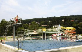 Das Wienerwaldbad in Purkersdorf mit Schwimmbecken, Sprungturm und Rutschen.
