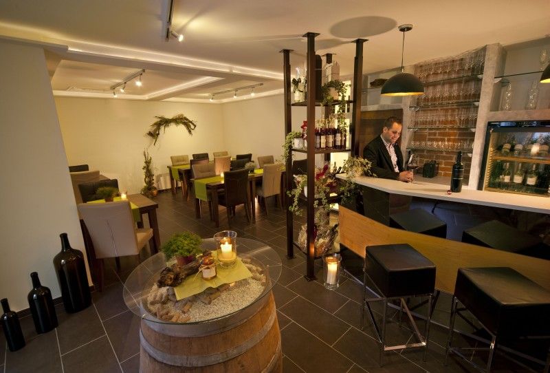 Ein stilvoller Verkostungsraum mit Bar, Tischen und Dekoration.