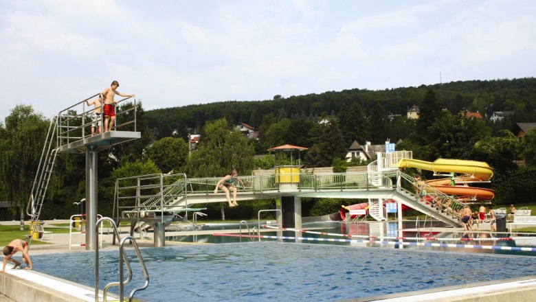 Das Wienerwaldbad in Purkersdorf mit Schwimmbecken, Sprungturm und Rutschen.