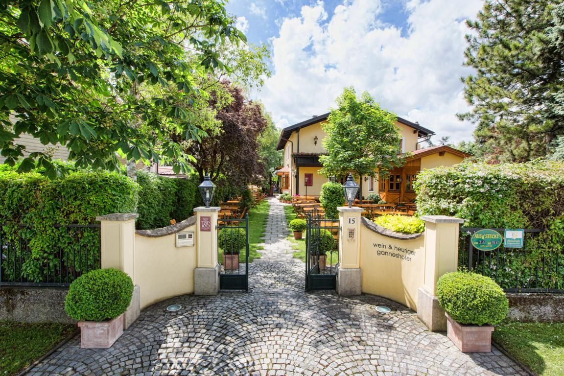 Eingang zu einem gemütlichen Gasthaus mit Garten und Sitzplätzen im Freien.