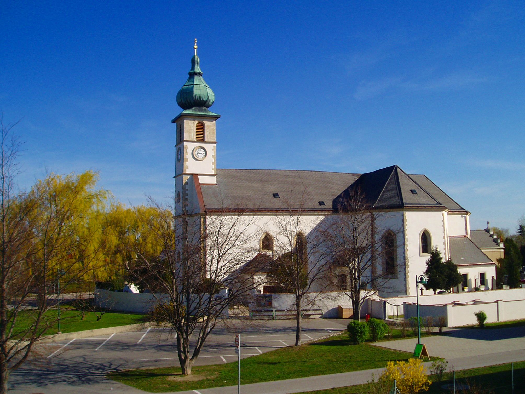 Kirche in Trumau mit blauem Himmel im Hintergrund.
