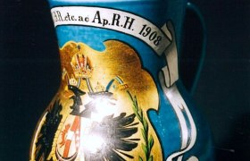 Ein verzierter Krug mit kaiserlichem Wappen und Inschrift von 1908.