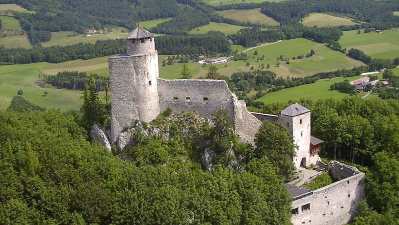 Aerial view of Araburg Castle, surrounded by green forests and hills.