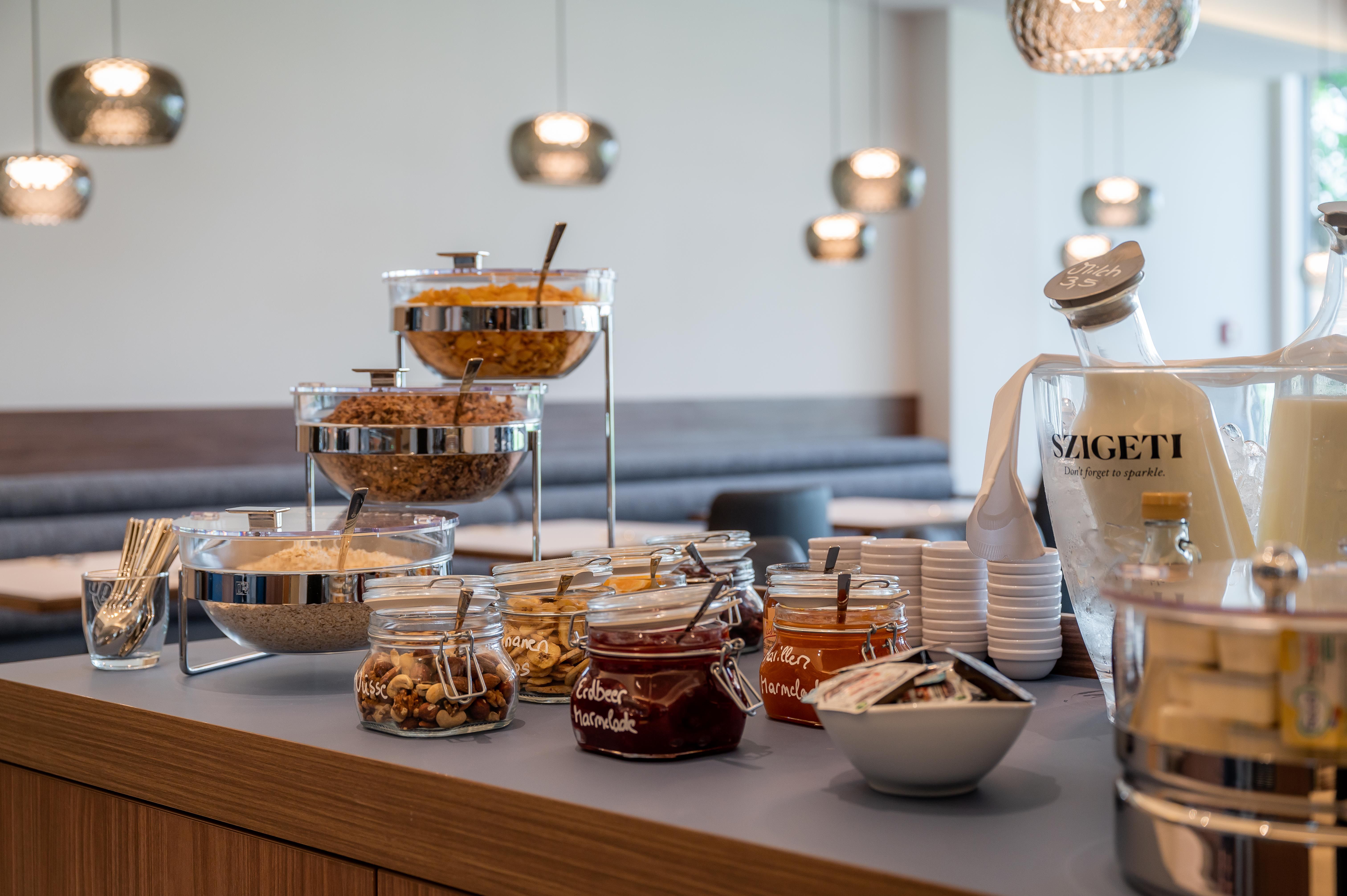 Frühstücksbuffet mit Müsli, Marmelade und Getränken.