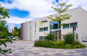Außenansicht des College Garden Hotels mit moderner Architektur und Garten.