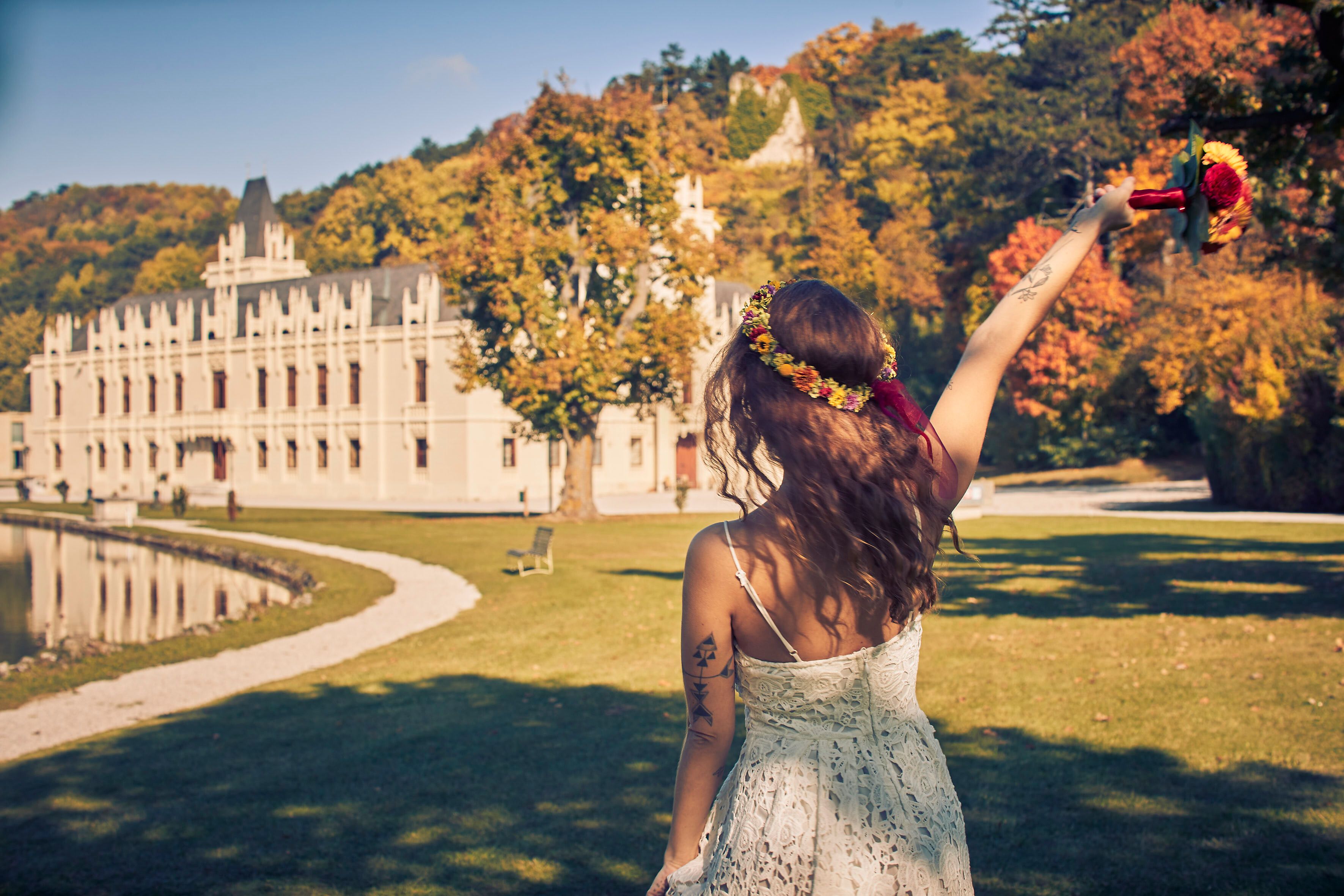 Inmitten der malerischen Kulisse des Schlosses Hernstein feiert eine Braut ihren besonderen Tag. Umgeben von bunten Herbstblättern und dem glitzernden Wasser des Teichs, strahlt sie Freude und Glück aus. Die romantische Atmosphäre lädt dazu ein, die Schönheit der Natur und die Liebe zu genießen.