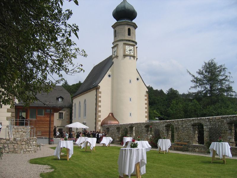 Kirche mit Turm und Garten mit Stehtischen, Hochzeitsszene.