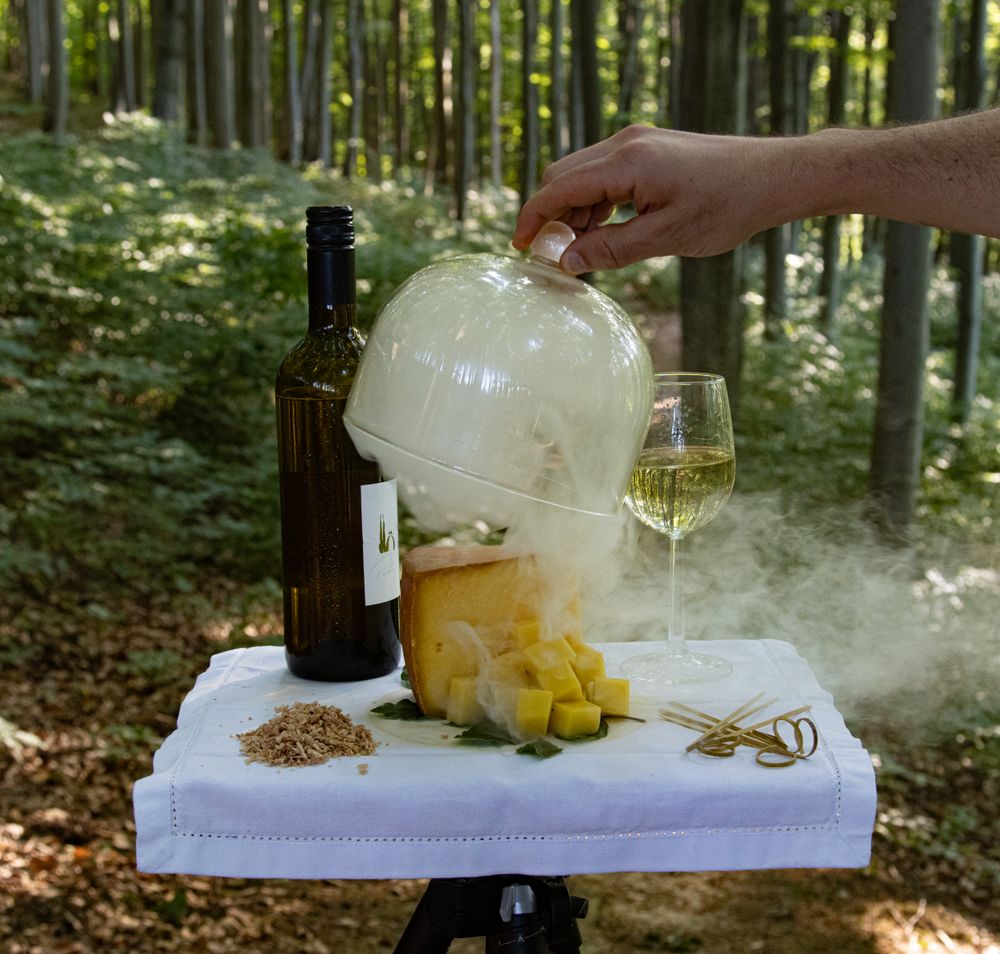 Inmitten der sanften Hügel des Wienerwaldes entfaltet sich eine faszinierende Kulisse, in der die frische Luft und der Duft von Kräutern die Sinne beleben. Ein geschickter Koch zaubert mit Leidenschaft und Kreativität ein einzigartiges Geschmackserlebnis, während der Rauch aus dem Glasgefäß sanft aufsteigt und die Neugier weckt.