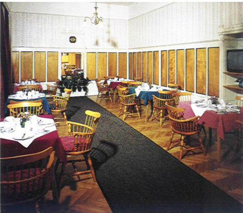 Ein Fr&uuml;hst&uuml;cksraum mit gedeckten Tischen und Holzm&ouml;beln.