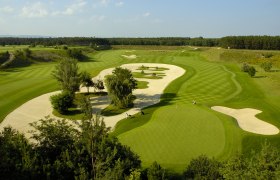Aerial view of a golf course with sand bunkers and manicured lawn.