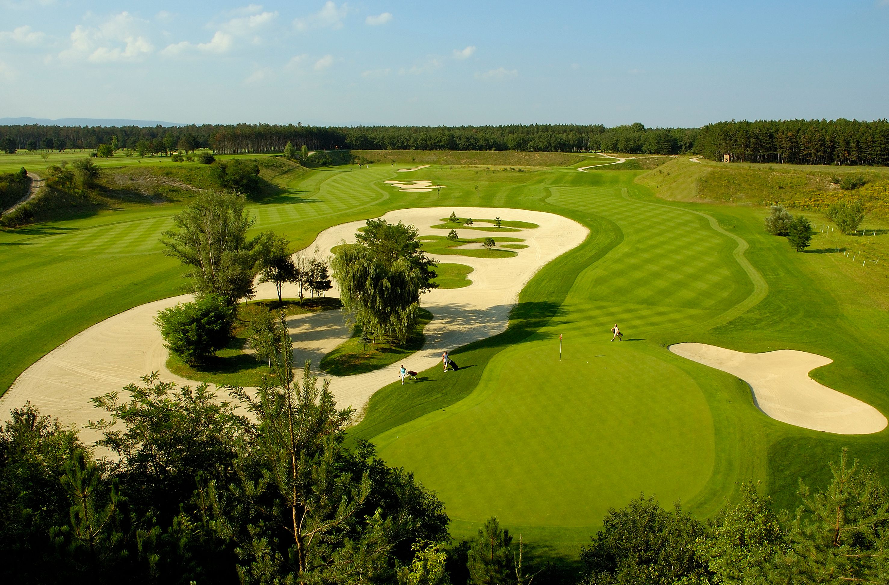 Luftaufnahme eines Golfplatzes mit Sandbunkern und gepflegtem Rasen.
