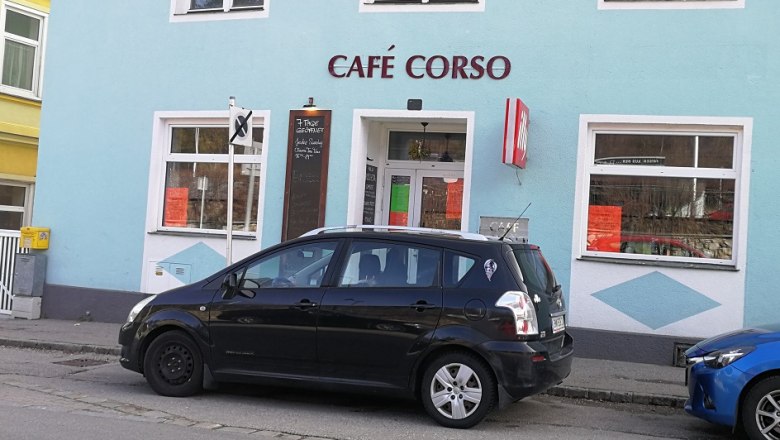 Außenansicht des Café Corso mit geparktem Auto davor.