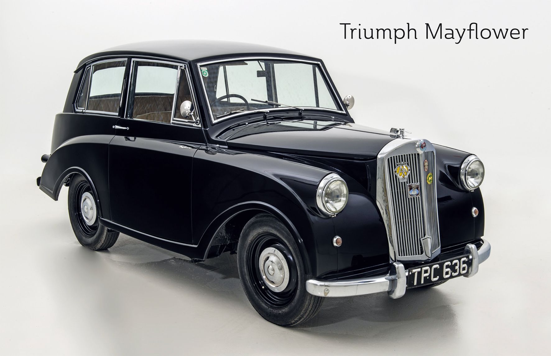 Ein schwarzer Triumph Mayflower Oldtimer vor weißem Hintergrund.