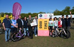 Gruppenfoto von Vertreterinnen und Vertretern der Veranstaltungsorganisation und der Region Wienerwald mit Gravelbikes und Veranstaltungsbannern im Hintergrund.