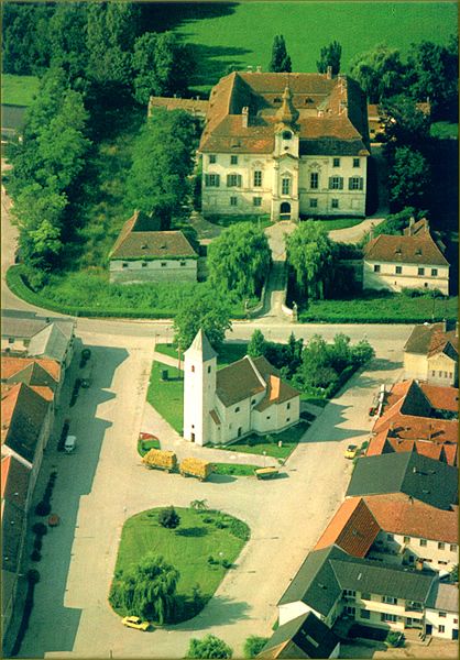 Luftaufnahme eines Dorfes mit Kirche und Schloss in Seibersdorf.