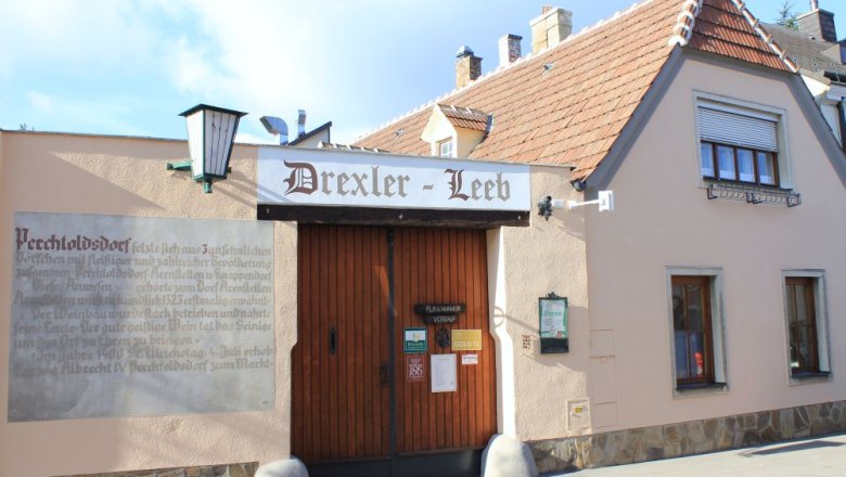 Traditional building with 'Drexler-Leeb' sign and wooden gate.