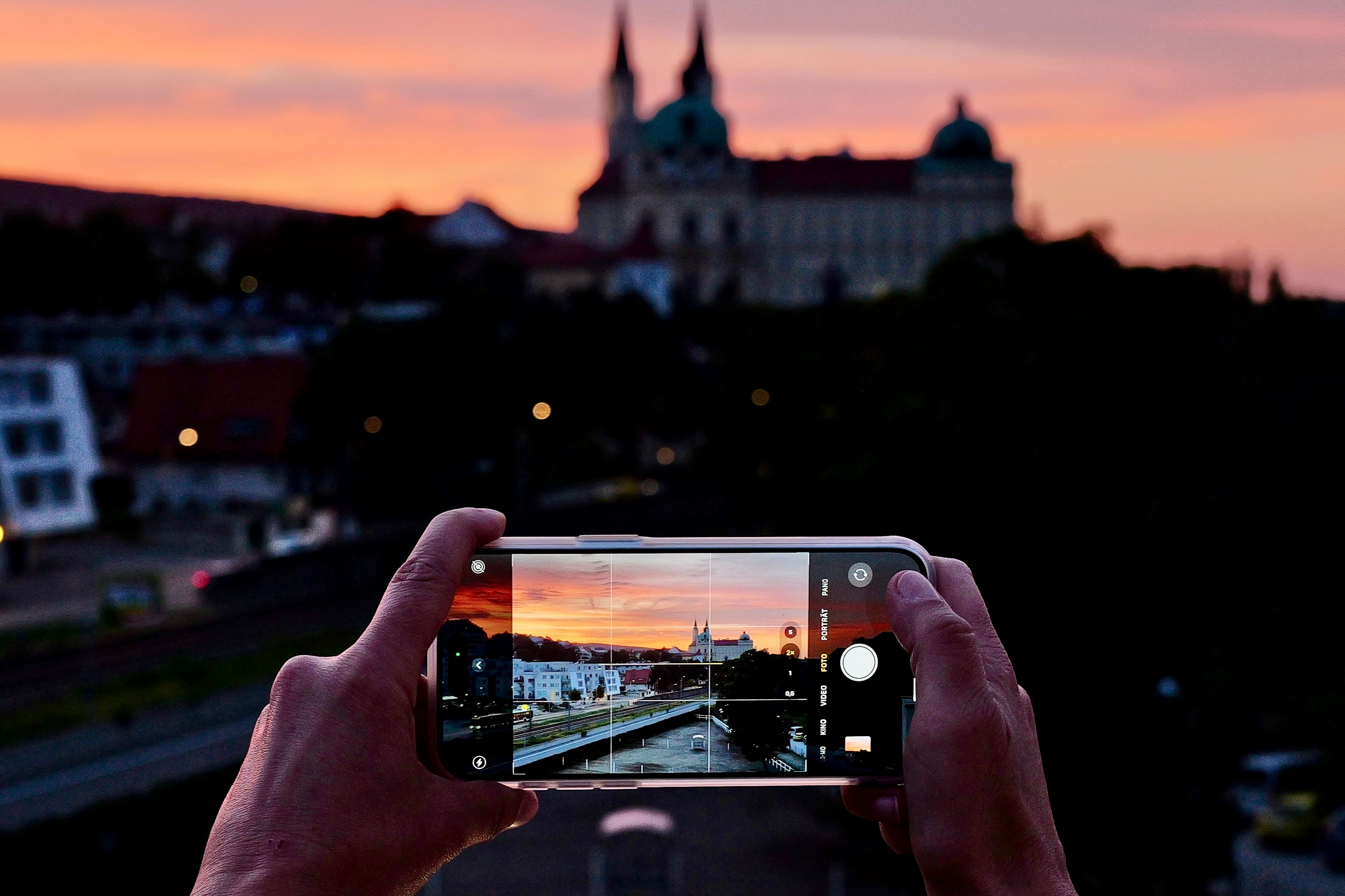 Der wunderschöne Abendstimmung mit Blick auf das Stift Klosterneuburg wird mit einem Mobiltelefon fotografisch eingefangen. 