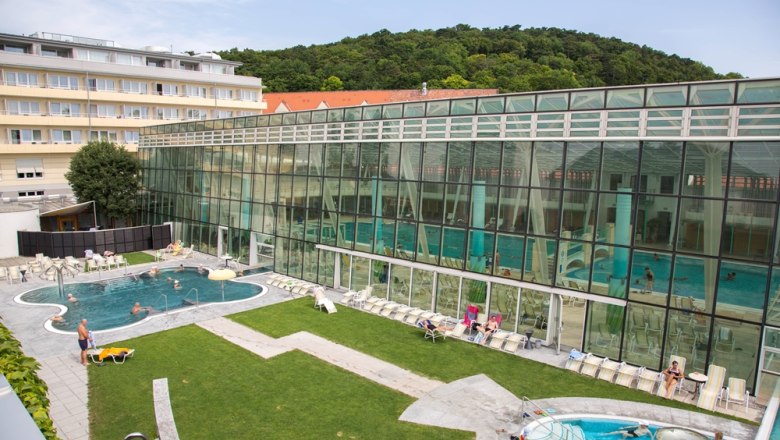 Exterior view of the Römertherme Baden with pool and glass façade.