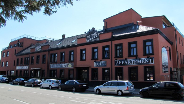 Außenansicht des Hotel Braugasthof Fabrik mit geparkten Autos davor.