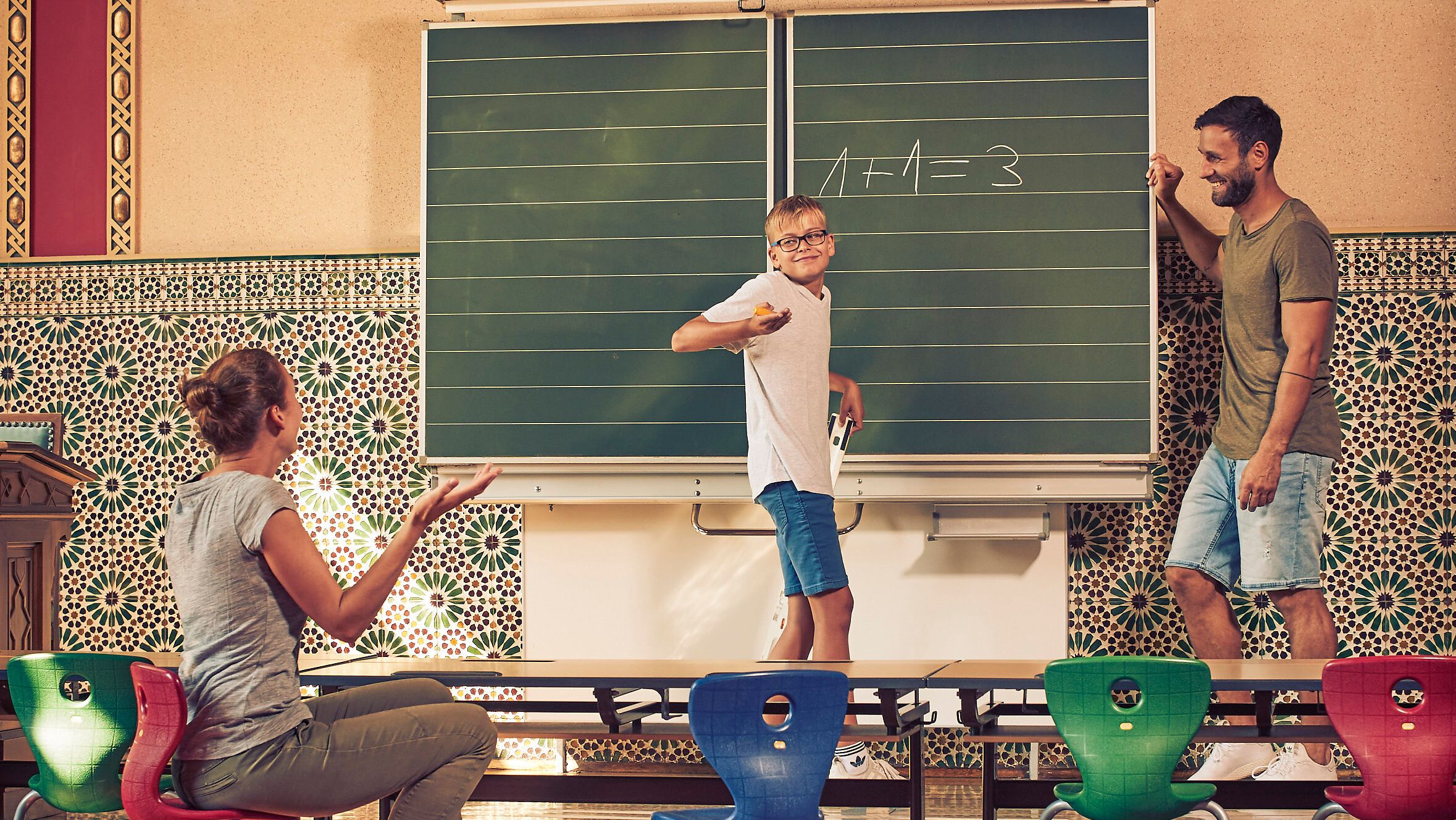 In einem einladenden Klassenzimmer voller Farben und Kreativität wird das Lernen zum Abenteuer. Eine Familie genießt die Zeit miteinander, während sie spielerisch Wissen vermittelt. Die harmonische Atmosphäre lädt dazu ein, die Schönheit der Natur und die Freude am gemeinsamen Entdecken zu erleben.