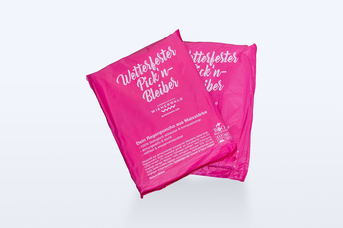 Magenta farbener Regenponcho aus Maisstärke im Genussmeilen Branding